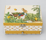 Boîte à bijoux Trousselier fermée avec Peter Rabbit dans le jardin sur le couvercle et un tiroir jaune